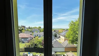 Weitblick über die grüne Wohngegend mit Einfamilienhäusern und blauem Himmel.