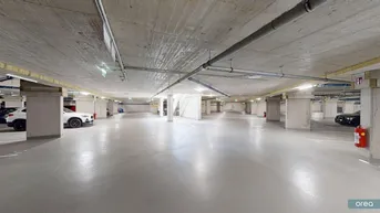 Geräumige Tiefgarage mit Betonwänden und -decken, hell beleuchtet und modern gestaltet.