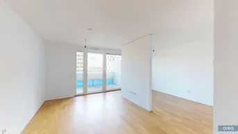 Helles Zimmer mit Holzboden und Zugang zu einem Balkon, geteilt durch eine Trennwand.