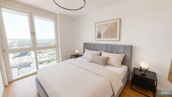 Helles Schlafzimmer mit modernem Design, großem Fenster und weitem Stadtblick.