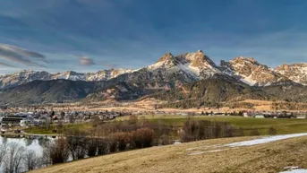 Panoramablick auf schneebedeckte Berge, einen See und eine malerische Stadt im Tal.
