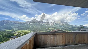 Geräumiger Holzbalkon mit atemberaubendem Bergblick und viel natürlichem Licht.