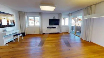Helles Wohnzimmer mit Holzboden, großen Fenstern und Zugang zu einem Balkon oder einer Terrasse.