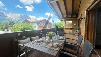 Geräumiger Balkon mit Esstisch und Stühlen, bietet einen atemberaubenden Blick auf die Berge.