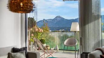 Helles Wohnzimmer mit gemütlicher Einrichtung und direktem Zugang zur Terrasse mit Bergblick.