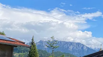 Panoramablick auf die majestätischen Berge unter einem strahlend blauen Himmel mit Wolken.