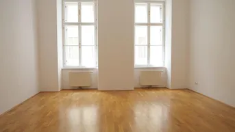 Helles Zimmer mit Parkettboden, weißen Wänden und zwei Fenstern, bereit zur individuellen Gestaltung.