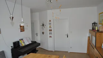 Heller Wohnbereich mit Holzboden, Esstisch und Klavier, der zu gemütlichen Stunden einlädt.