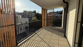 Geräumiger Balkon mit Fliesenboden, Holzlamellen als Sichtschutz und viel Sonnenlicht.