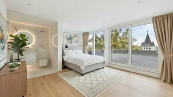 Modernes Schlafzimmer mit integriertem Badbereich, Holzboden und großen Fenstern mit Ausblick.
