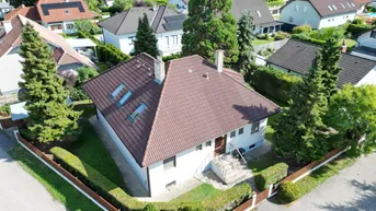 Luftaufnahme eines Einfamilienhauses mit braunem Ziegeldach und gepflegtem Gartenbereich.