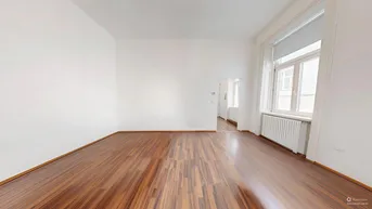 Helles Zimmer mit Holzboden und weißen Wänden, ideal als Wohn- oder Schlafzimmer nutzbar.