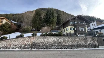 Traditionelles Haus in alpiner Umgebung mit Steinfassade und verschneiter Landschaft.