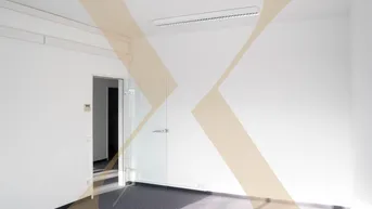 Helles, leeres Büro mit Teppichboden und Glastür, bereit für die individuelle Gestaltung.