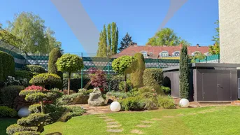 Gepflegter Garten mit Rasenfläche, Ziersträuchern und einem praktischen Gartenschuppen.