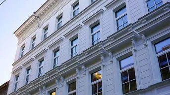 Historische Fassade eines eleganten Gebäudes mit vielen Fenstern und architektonischen Details.