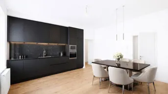 Moderne offene Küche mit schwarzen Schränken und Essbereich, ideal für geselliges Beisammensein.