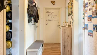 Heller Flur mit Garderobe, Schuhbank und persönlicher Wanddekoration, die einen einladenden Eingangsbereich schafft.