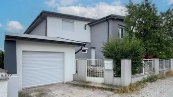 Modernes Einfamilienhaus mit integrierter Garage und gepflegtem Vorgartenbereich.