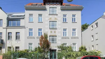 Historisches Mehrfamilienhaus mit klassischer Fassade und gepflegtem Vorgarten in sonniger Lage.