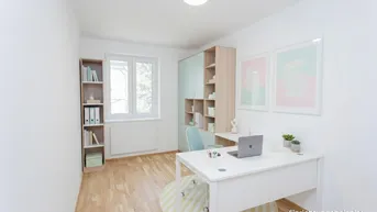 Helles Büro mit modernem Schreibtisch, Regalen und Parkettboden, als Einrichtungsbeispiel.