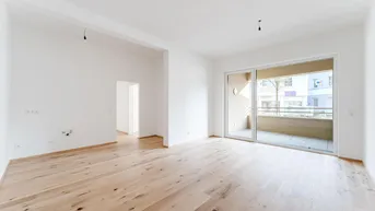 Helles, leeres Wohnzimmer mit Holzboden und Zugang zu einem Balkon, bereit zum Einzug.