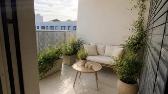 Heller Balkon mit Fliesenboden, bequemen Gartenmöbeln und grünen Pflanzen für entspannte Stunden im Freien.