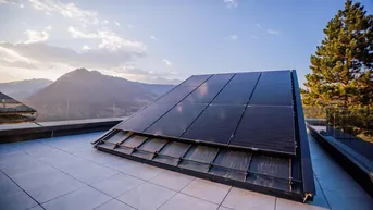 Photovoltaikanlage auf der Dachterrasse, die nachhaltige Energie mit Bergblick verbindet.