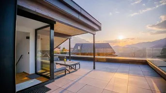 Großzügige Dachterrasse mit bequemen Lounge-Möbeln und einem weiten Panoramablick auf die Berge.