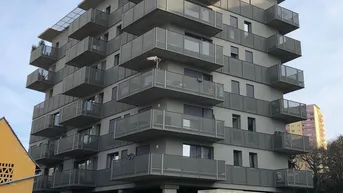 Modernes Mehrfamilienhaus mit zahlreichen Balkonen und zeitgenössischer Architektur.