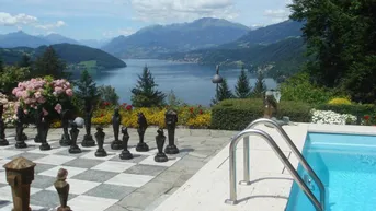 Außenbereich mit Pool, großem Schachspiel und atemberaubendem Blick auf den See und die Berge.