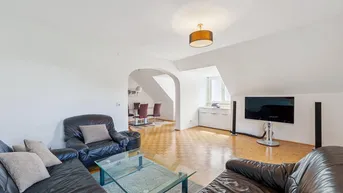 Heller Wohn- und Essbereich mit Parkettboden, Dachschrägen und gemütlichen Ledersofas.