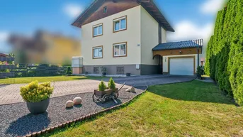 Gut gepflegtes Einfamilienhaus mit traditioneller Architektur, Satteldach, Garage und einem grünen Vorgarten.