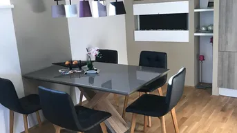 Moderner Essbereich mit großem Tisch, schwarzen Stühlen und dekorativem Kamin.