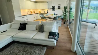 Helles, offenes Wohnzimmer mit integrierter Küche, Essbereich und Zugang zur Terrasse.