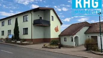 Ansicht des Wohnhauses von der Straße mit Balkon und gepflegtem Vorgarten.