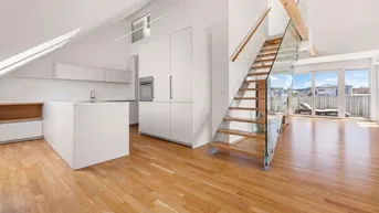 Heller offener Wohnbereich mit moderner Küche, Holzboden und Zugang zur Terrasse.