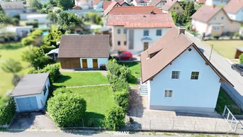 Luftaufnahme des Anwesens mit Haupthaus, Nebengebäude und Garten in einer Wohnsiedlung.