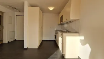 Kompakte Küchenzeile in hellem Design mit ausreichend Stauraum und Arbeitsfläche.