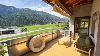 Geräumiger Balkon mit Sitzgelegenheiten, Holzbalkendecke und atemberaubendem Bergblick.