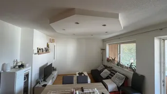 Heller Wohn- und Essbereich mit Holzboden, Esstisch und gemütlicher Sofaecke, ideal für gesellige Stunden.