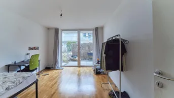 Helles Schlafzimmer mit Holzfußboden und direktem Zugang zu einem kleinen Außenbereich.