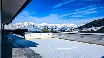 Große, schneebedeckte Terrasse mit atemberaubendem Panoramablick auf die verschneiten Berge.
