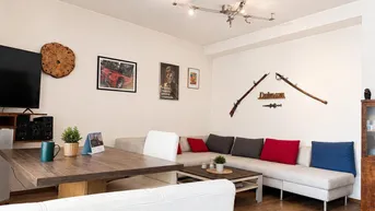 Geräumiger Wohn-Essbereich mit großem Sofa, Esstisch und Holzboden.