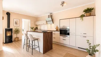 Moderne offene Küche mit Kochinsel, integrierten Geräten und gemütlichem Holzofen.