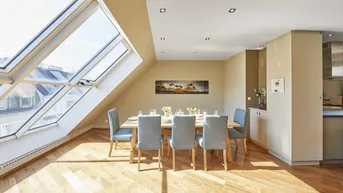 Heller Essbereich im Dachgeschoss mit großen Dachfenstern, Holzboden und modernem Esstisch.