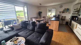 Geräumiger offener Wohn- und Essbereich mit moderner Küche und Zugang zum Balkon mit Weitblick.