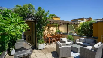 Große Dachterrasse mit Grillbereich, Essplatz und gemütlichen Loungemöbeln unter einer Pergola.