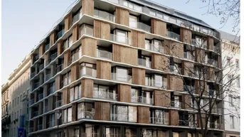 Moderne Architektur mit Glasfassade und Balkonen in urbaner Umgebung.