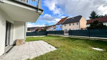 Ebenerdige Terrasse mit angrenzendem Rasenbereich und Blick auf die Nachbarschaft.